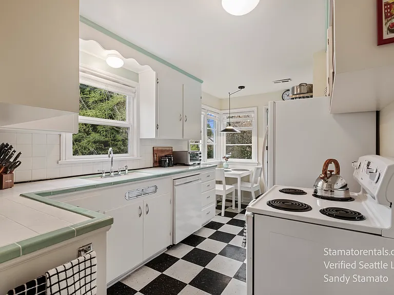 The adjoining 1946 kitchen features original tile and checkered floors, updated appliances, and everything you need_from simple meals to gourmet cooking.