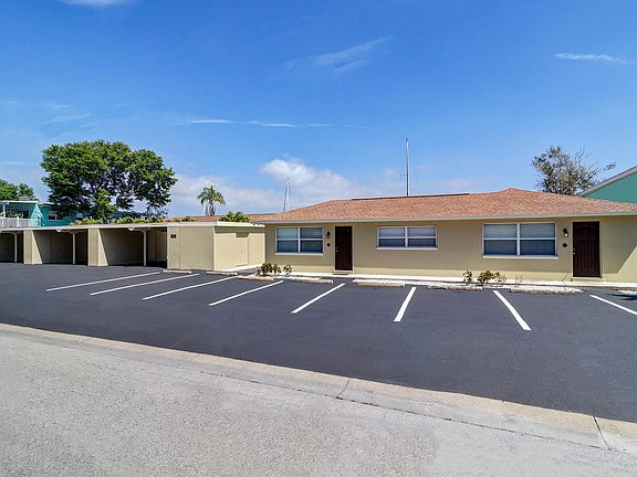 Street side view of complex. Units 1 - 6 are located directly on the water behind the carports and duplex (unit 7 & 8)