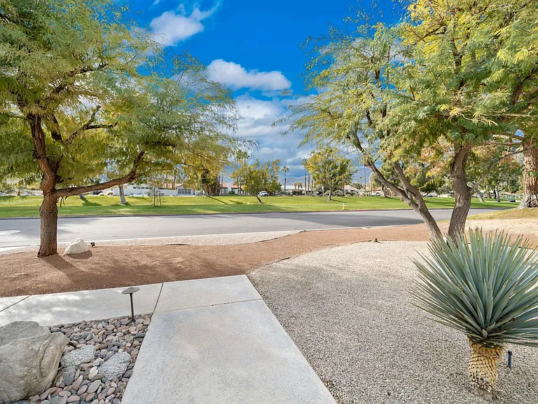 Looking from front of home to street with large grassy median.