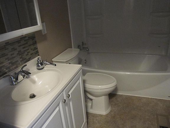 Newer tub, vanity, toilet, mirror.