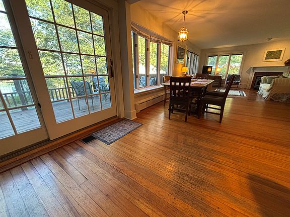 Open concept living and dining, with French doors to deck and view of tidal bay