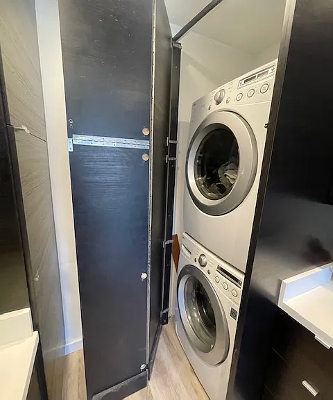 Washer dryer in kitchen behind cabinets