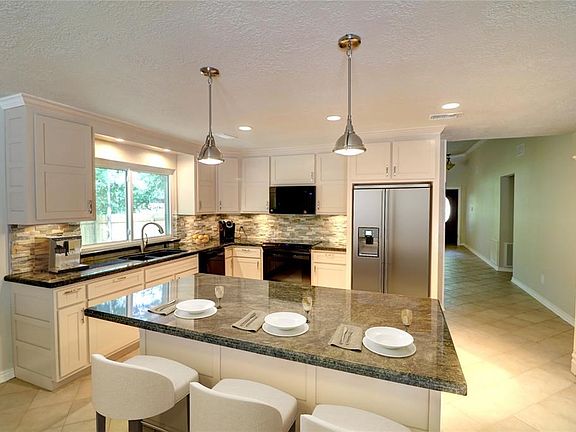 Cook in the well planned kitchen with granite countertops, island and large window above kitchen sink is a joy.