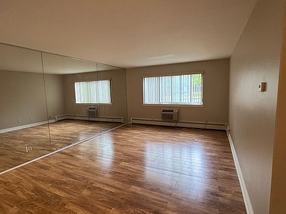 Large living room with lots of natural light + in wall a/c unit.