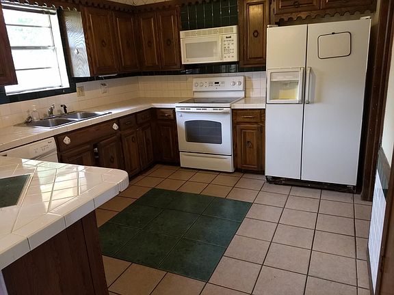Kitchen floor and counter tiled, refrigerater, range, diahwasher, disposal furnished