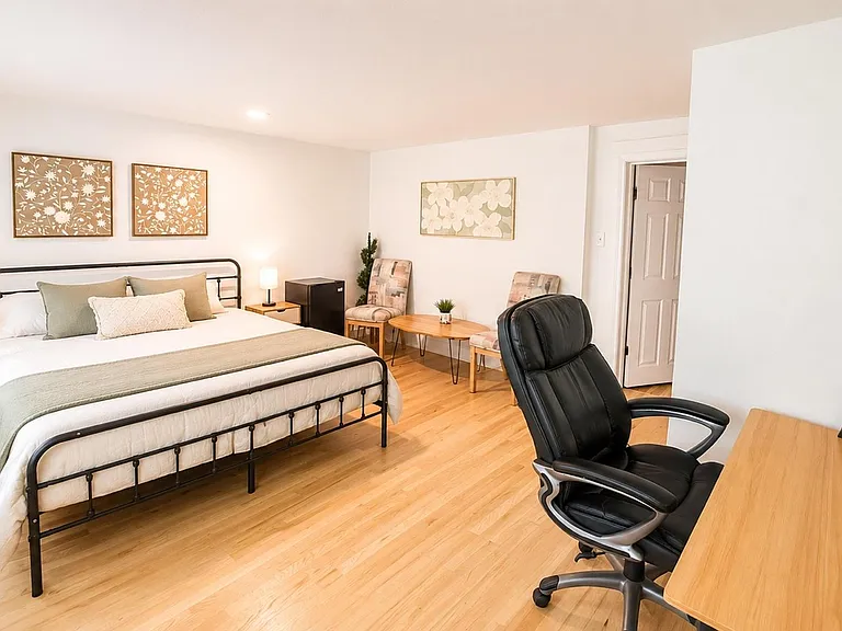Spacious room with king-size bed, private entrance, mini fridge, private bathroom & workspace. Bedding not included.