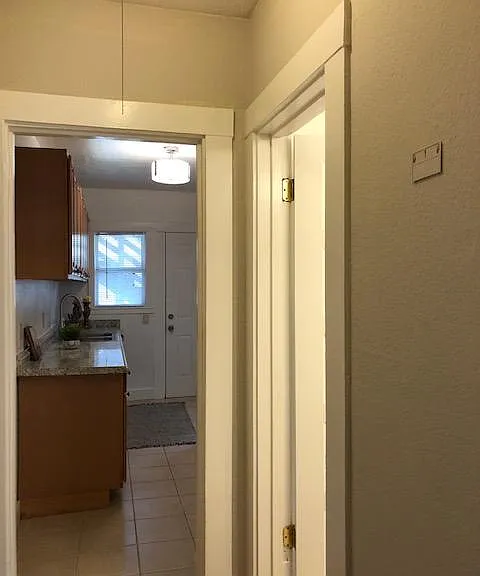Hall from the living space to the bathroom and the kitchen has wood laminate flooring