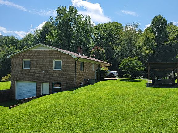 Back of home with full basement, new door, garage door, and windows.