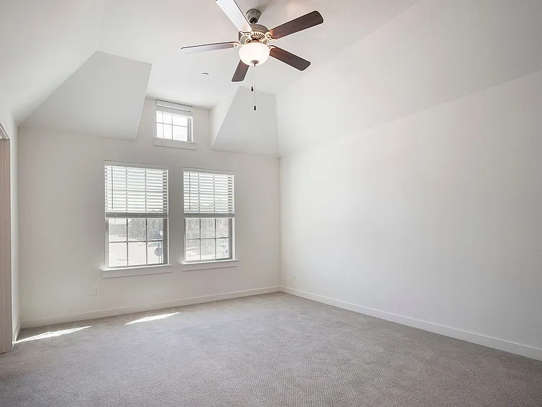The fabulous, vaulted ceiling primary bedroom is spacious with plenty of space for a sitting area.