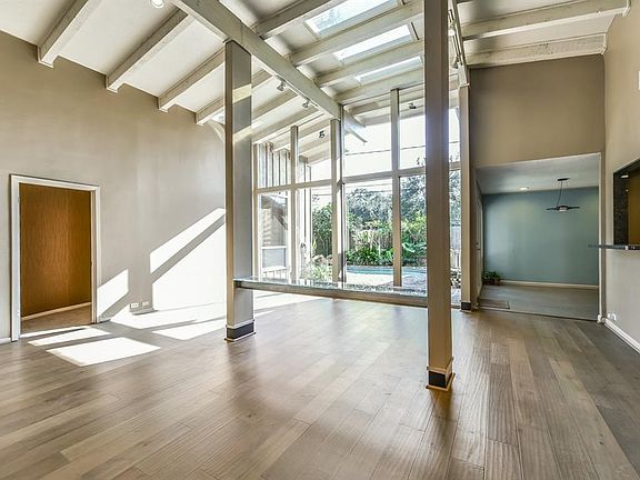 An alternate view of the great room which opens to breakfast area has vaulted 14 foot ceilings accented with beams and skylights.