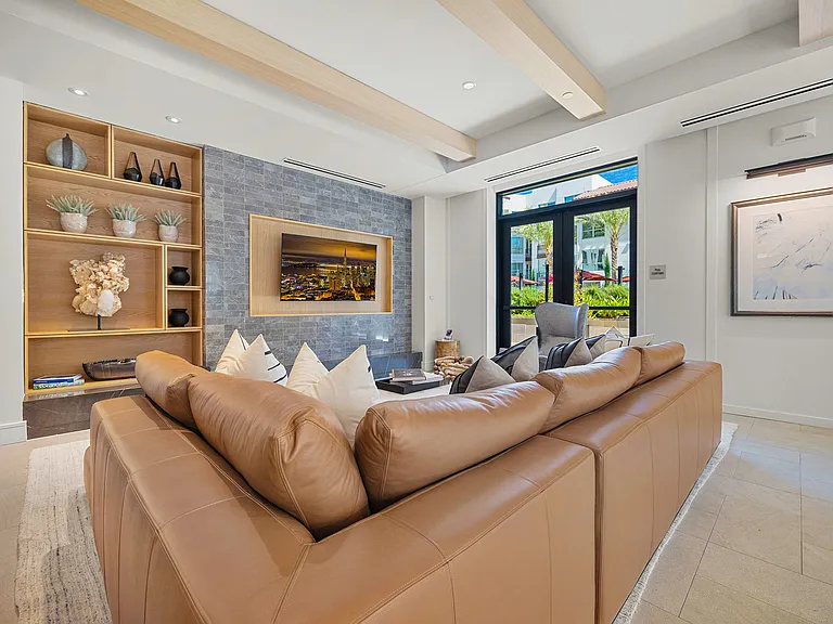 Clubroom lounge with leather sectional, shelving, and big-screen