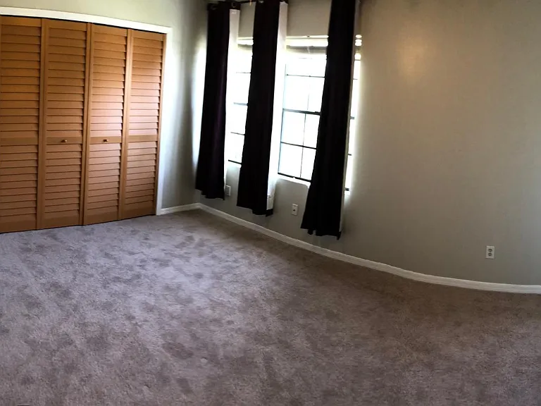Second bedroom with new carpet and closet doors.