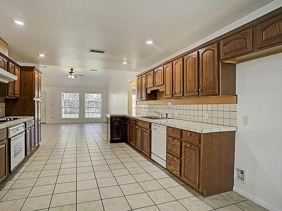 Large open kitchen equipped with gas cooktop, single oven and dishwasher.