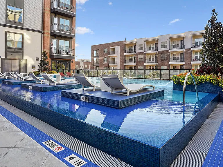 Resort-style pool with lounge chairs and gazebos.