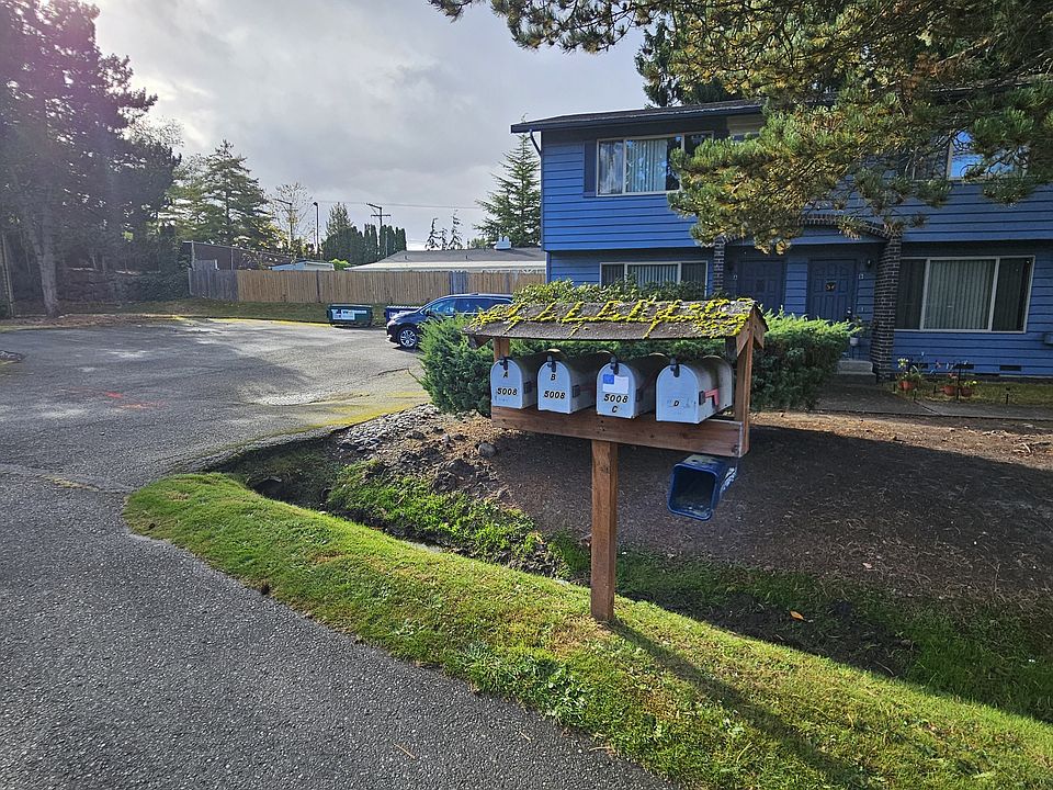 Mail delivery at post box in front yard.