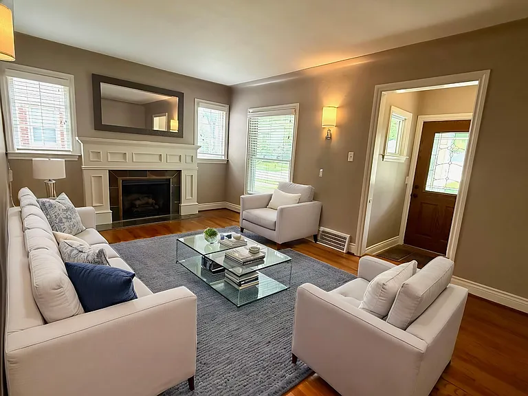 Living room with fireplace, entry has closet. Virtually staged to show possibilities