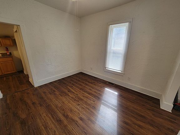 Dining room; arched doorway to living room is on right; doorway to kitchen on left