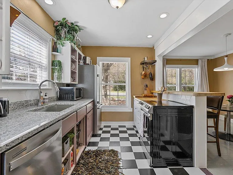Kitchen at Hunsucker's was completely remodeled in 2023 and features stainless appliances and checkerboard tile floor all within walking distance of Downtown and Cone Hospital
