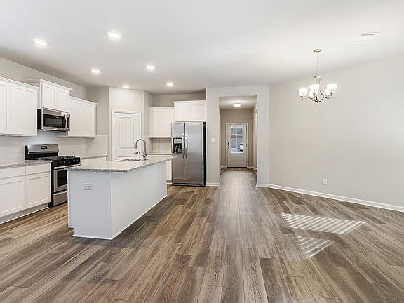 Kitchen complete with granite countertops, hardwood floors, and stainless steel appliances!