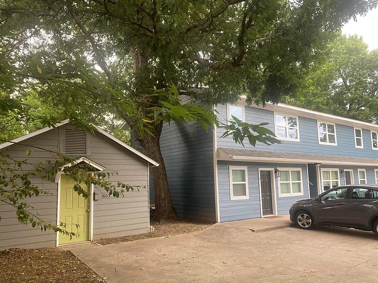 Small building with yellow door is laundry room.