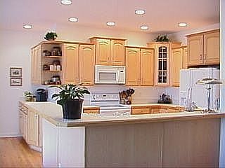 Open kitchen with abudant birch cabinets and walk-in pantry