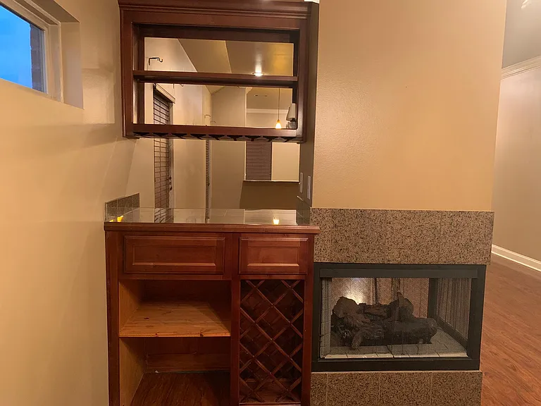 Stunning wine bar and triple sided gas burning fireplace! See it from any view of the Kitchen, Living room, and Dining Room!