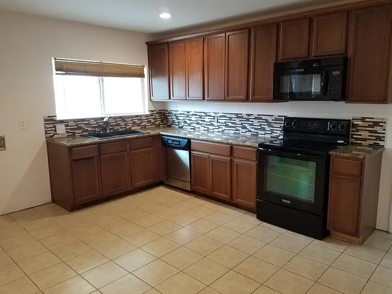 Clean kitchen with sliding windows to back yard