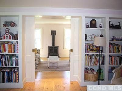 Family room with built in bookcases, pocket doors open into living room. Beautiful wideboard floors throughout the house.