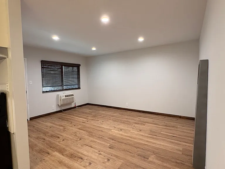 Large living area with wall, AC unit and furnace