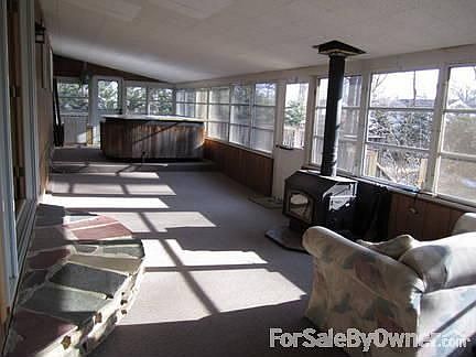 Sunroom - overlooking nature at its best : Jacuzzi, door leads to side deck. Woodstove, door leads t