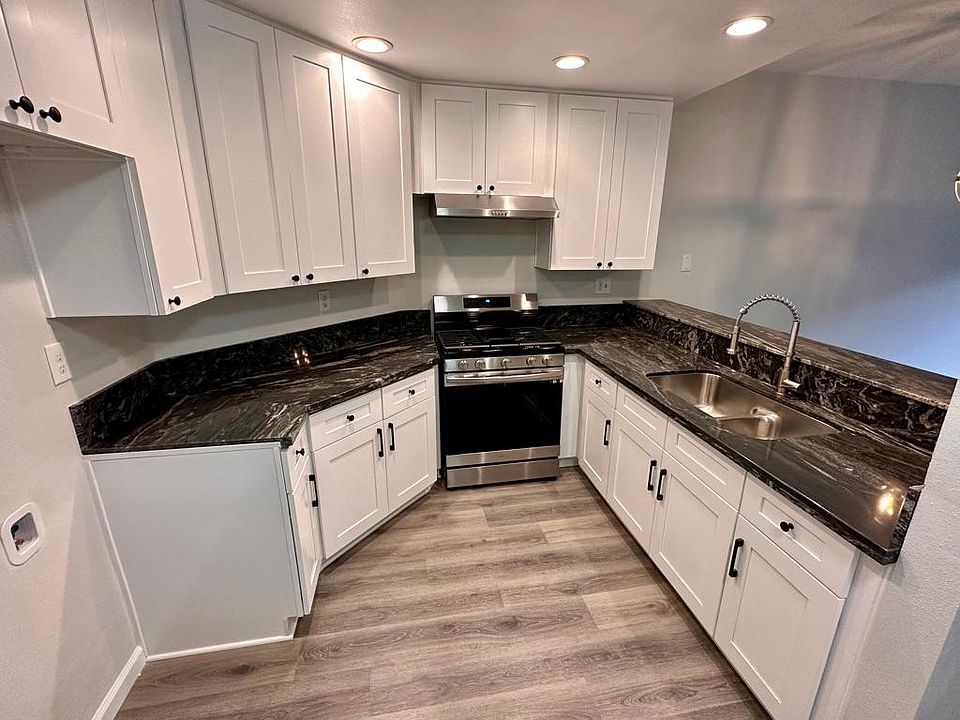 Spacious kitchen with new cabinets, quartz countertops, faucet, garbage disposal, stove and breakfast bar.