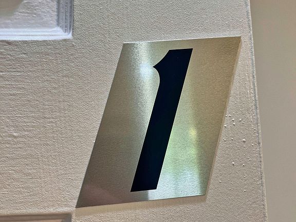 Common-area hallway with clearly labeled room/door numbering to help residents navigate the home with ease.
