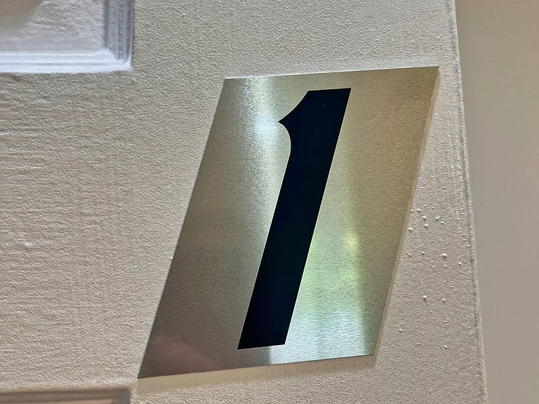 Common-area hallway with clearly labeled room/door numbering to help residents navigate the home with ease.