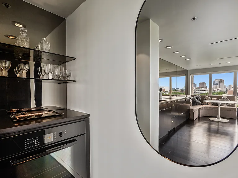 Dedicated dry bar with glass display shelving and a built-in Bosch oven.