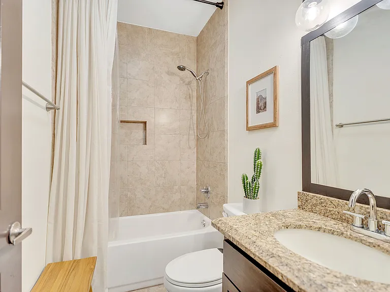 Sophisticated bathroom showcasing a shower curtain and toilet, part of La Joya Apartments in Laredo, Texas