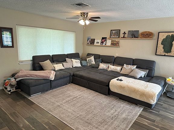 Large living area with floating shelves and TV mount