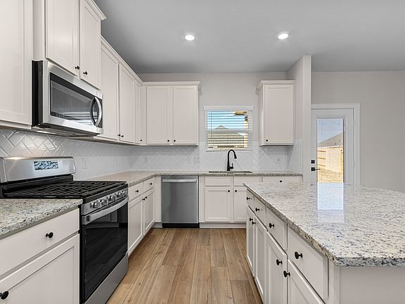 Enjoy stunning granite countertops and designer wood cabinetry in this kitchen.