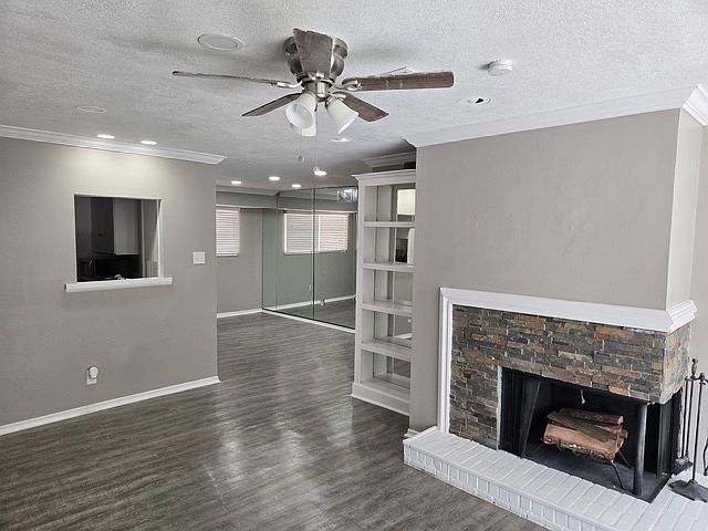 Living area with fireplace, ceiling fan and built-ins.