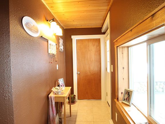 Entry with knotty pine accents and tile floor.