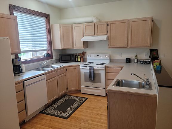 Roomy kitchen equipped with small appliances and kitchen tools. Kitchen also has two stainless steel sinks.