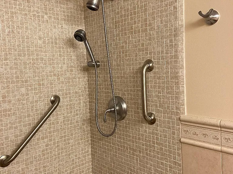 Kohler plumbing fixtures, fixed and hand shower head, grab bars, robe hook.