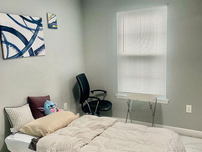 Private bedroom with tiled floors, overhead lighting, and space for a bed plus a desk setup for studying or remote work.