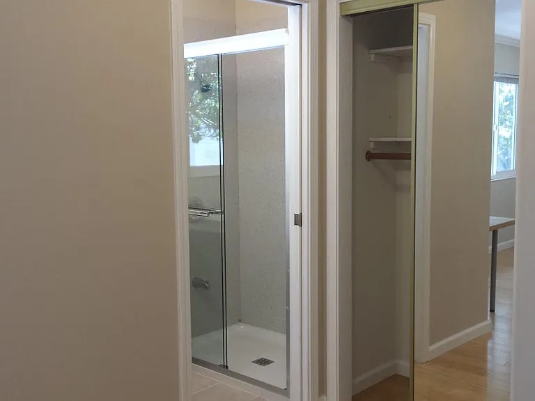 Master bathroom with bathroom and sliding mirror door closet
