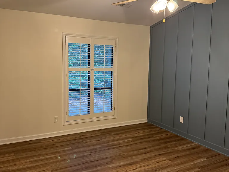 Master bedroom. Ceiling fan, cathedral ceilings, textured accent wall and plantation shutters.