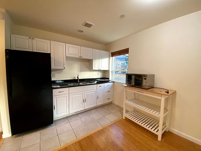 Kitchen with full size refrigerator, countertop burner, microwave, and convection oven