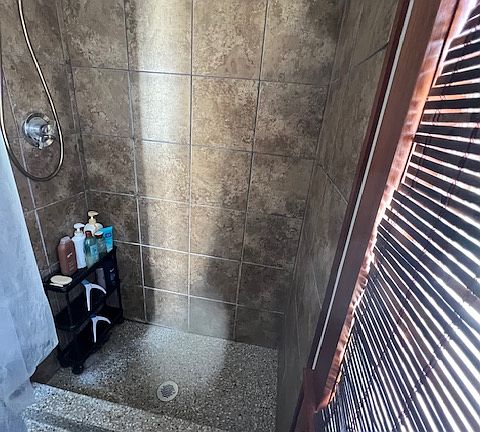 Tile shower, epoxy bathroom and shower floor. Large private window in bathroom with sink/vanity/storage shower fan/light/heater and water closet.