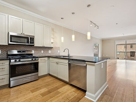 Stainless steel appliances and granite countertops in designer kitchen