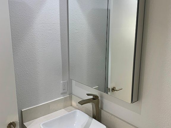 Bathroom vanity with modern sink, fixtures and quartz stone counters