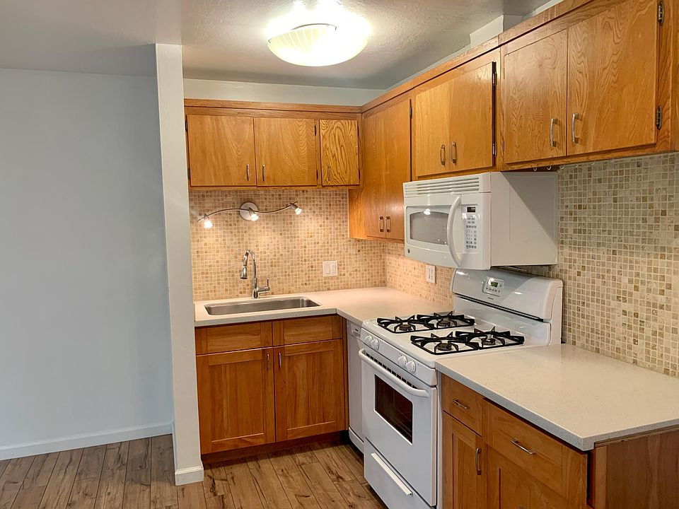 Kitchen featuring gas stove, microwave, dishwasher, large sink, granite countertops