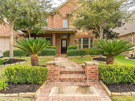 A closer look shows the covered front patio and well manicured landscaping.